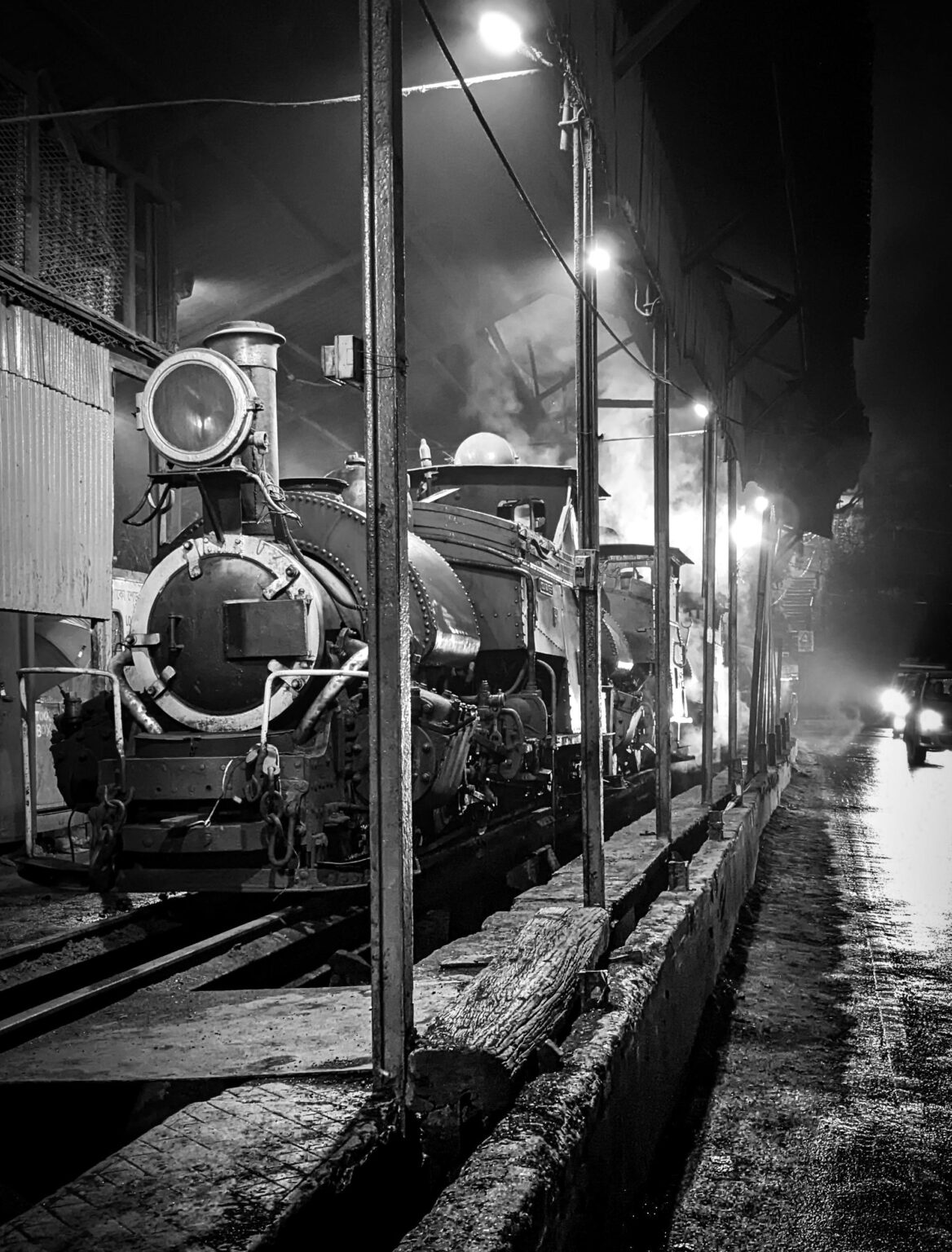 Black and white image of a vintage locomotive at night in Darjeeling, India.