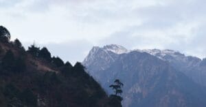 Breathtaking view of the Himalayas in Lachen, India with lush greenery and cloudy skies.
